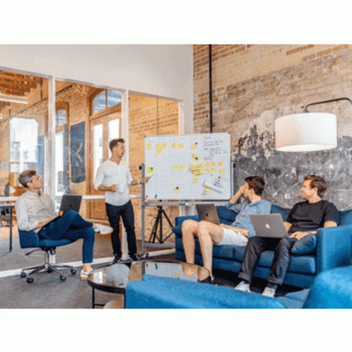 A Man Is Giving A Presentation To A Group Of People Sitting On A Couch GIF