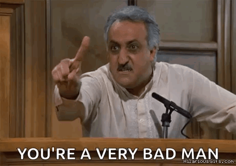 A Man Is Giving A Speech At A Podium And Pointing At The Audience . GIF