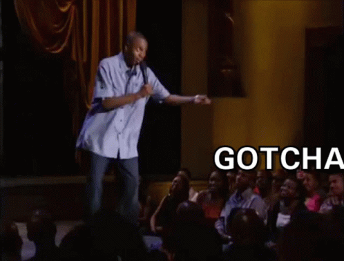 A Man Is Giving A Speech In Front Of A Crowd And The Words Gotcha Bitch Are On The Screen Behind Him GIF