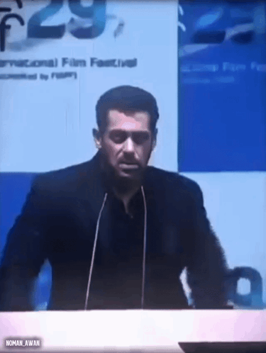 A Man Is Giving A Speech In Front Of A Microphone At A Conference . GIF