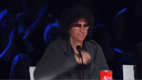 A Man Is Giving A Thumbs Up In Front Of A Microphone GIF