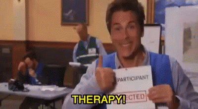 A Man Is Giving A Thumbs Up While Holding A Piece Of Paper That Says Therapy . GIF