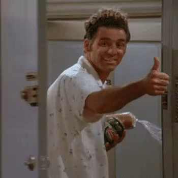 A Man Is Giving A Thumbs Up While Holding A Spray Bottle In His Hand . GIF