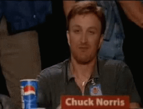 A Man Is Giving A Thumbs Up With The Words Chuck Norris Approves Behind Him . GIF