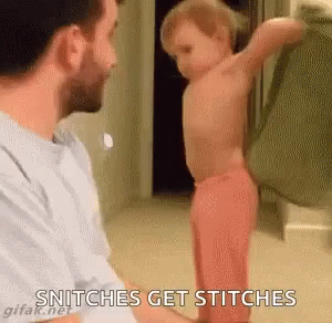 A Man Is Holding A Baby In His Arms While The Baby Is Standing In Front Of Him . GIF