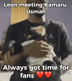 A Man Is Holding A Baby In His Arms With A Caption That Says Leon Meeting Kamaru Usman Always Got Time For Fans GIF