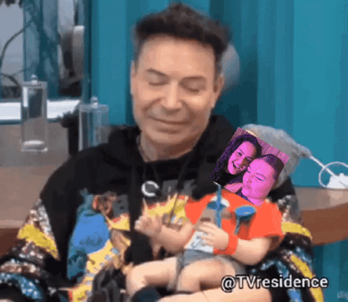a man is holding a baby in his arms with a picture of a woman behind him and the hashtag tvresidence