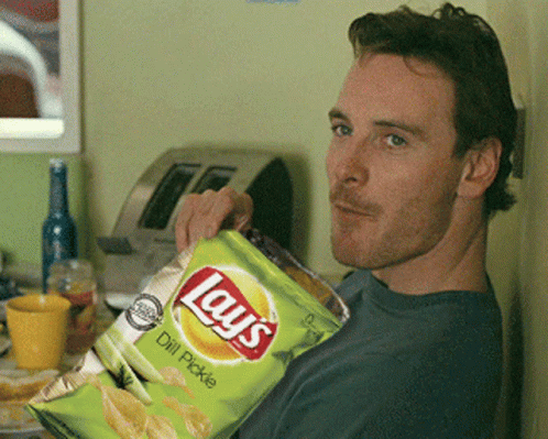 A Man Is Holding A Bag Of Lays Chips GIF