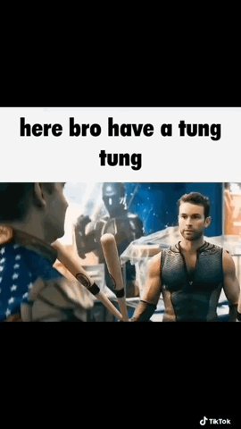 A Man Is Holding A Baseball Bat And Talking To Another Man In A Boxing Ring . GIF