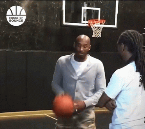 a man is holding a basketball in front of a basketball hoop that says house of bounce