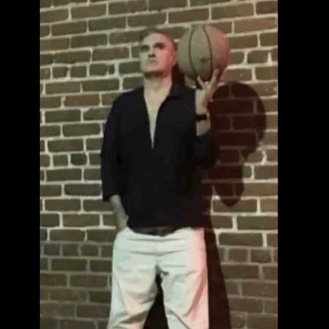 Man Holding Basketball In Front Of Brick Wall GIF