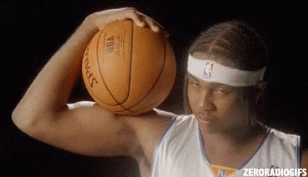 A Man Is Holding A Basketball Over His Head . GIF