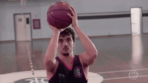 A Man Is Holding A Basketball Over His Head While Playing Basketball On A Court . GIF
