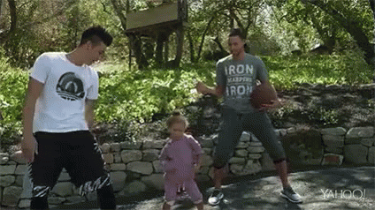 A Man Is Holding A Basketball While Two Other Men Are Dancing With A Little Girl . GIF