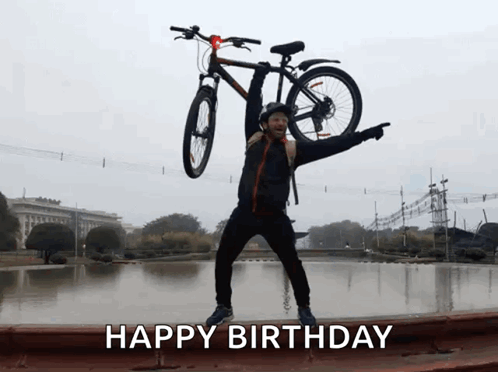 A Man Is Holding A Bicycle Over His Head And The Words Happy Birthday Are Below Him GIF