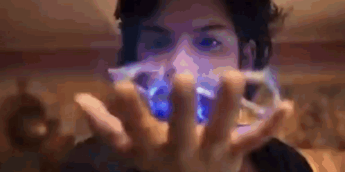 A Man Is Holding A Blue Object In His Hands GIF