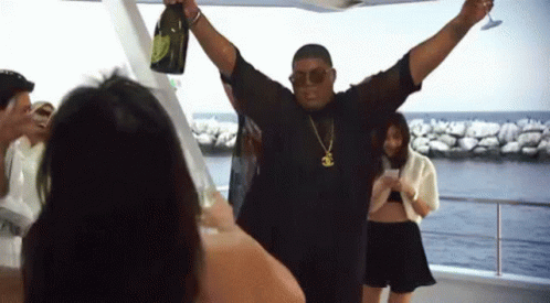 A Man Is Holding A Bottle Of Champagne And A Glass GIF