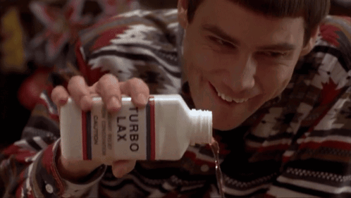 A Man Is Holding A Bottle Of Turbo Lax And Smiling GIF