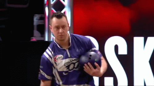 A Man Is Holding A Bowling Ball In Front Of A Sign That Says " Sk " GIF