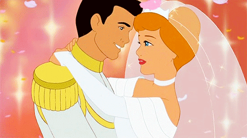A Man Is Holding A Bride And Groom In His Arms GIF