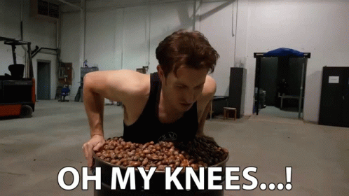 A Man Is Holding A Bucket Of Nuts With The Words Oh My Knees Written Below Him GIF