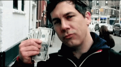 A Man Is Holding A Bunch Of Money In His Hand And Making A Face . GIF