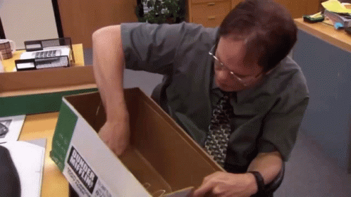 A Man Is Holding A Cardboard Box With A Label That Says Business Mix Ltd. GIF