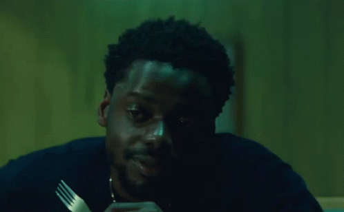 A Man Is Holding A Fork In His Hand And Saying `` Damn '' While Eating . GIF