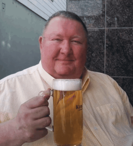 A Man Is Holding A Glass Of Beer That Says Kon GIF