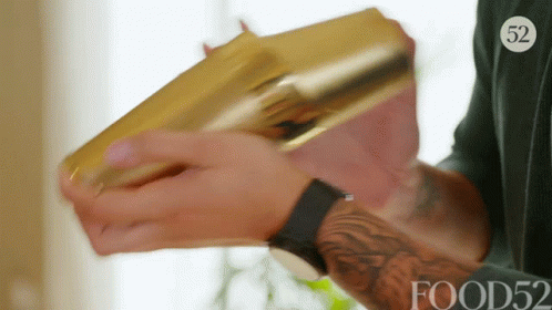 A Man Is Holding A Gold Shaker With The Number 52 On His Shirt GIF