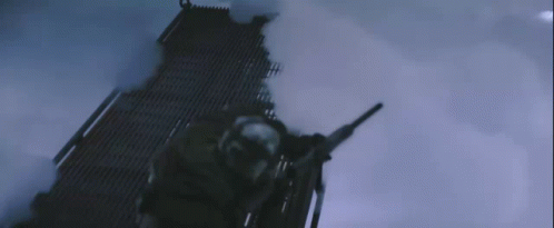 A Man Is Holding A Gun In A Dark Room With Smoke Coming Out Of It GIF