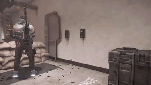 A Man Is Holding A Gun In A Room With A Bunch Of Bullets Flying Around Him . GIF