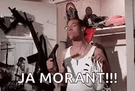 A Man Is Holding A Gun In A Room With The Words `` Ja Morant !!! '' Written On It . GIF