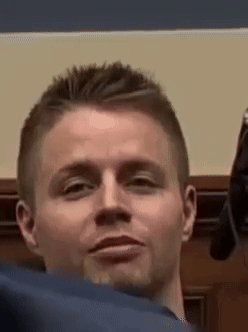 A Man Is Holding A Gun In His Hand And Making A Face . GIF