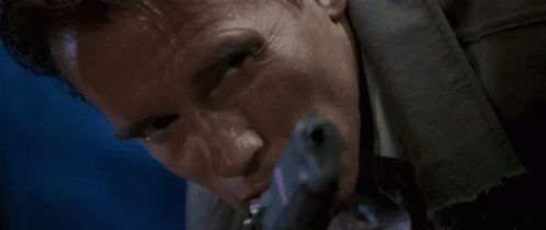 A Man Is Holding A Gun In His Mouth GIF