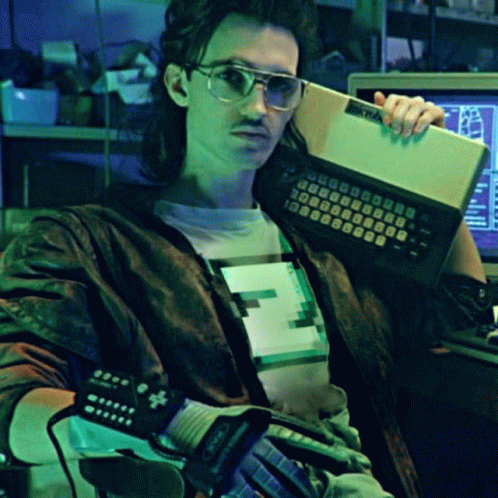 A Man Is Holding A Keyboard That Says Atari GIF