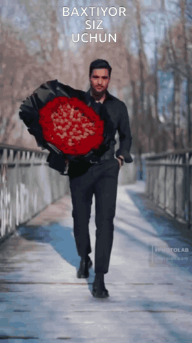 A Man Is Holding A Large Bouquet Of Red Roses With The Words Baxtior Siz Uchun Written On The Bottom GIF