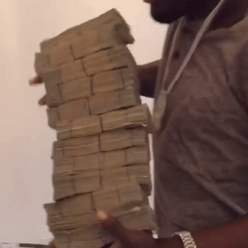 A Man Is Holding A Large Pile Of Money GIF
