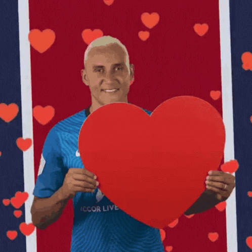 A Man Is Holding A Large Red Heart In His Hands GIF