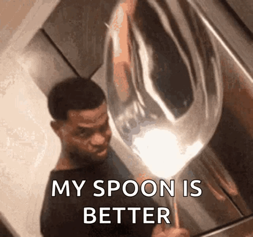 A Man Is Holding A Large Silver Spoon And Says " My Spoon Is Better " GIF