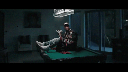 A Man Is Holding A Large Stack Of Money In His Hand . GIF