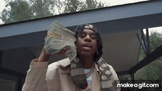 A Man Is Holding A Large Stack Of Money In His Hands . GIF