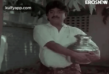 a man is holding a large vase in his hands .