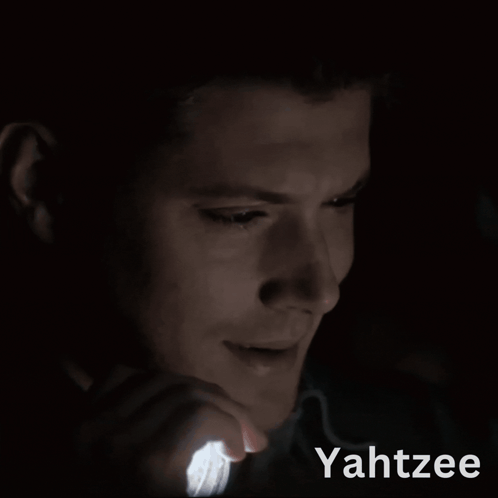 A Man Is Holding A Light In His Hand And The Word Yahtzee Is On The Bottom GIF