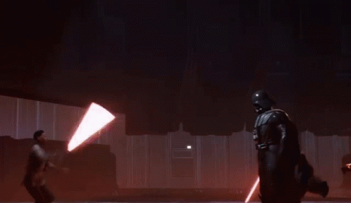 A Man Is Holding A Lightsaber While Another Man Sits On The Ceiling GIF