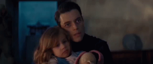 A Man Is Holding A Little Girl In His Arms And The Little Girl Is Looking At The Camera . GIF