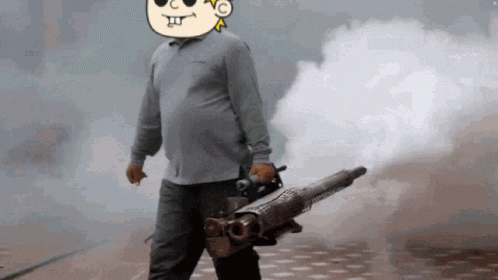 A Man Is Holding A Machine Gun With Smoke Coming Out Of It While Wearing Sunglasses . GIF