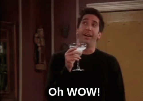A Man Is Holding A Martini Glass And Saying `` Oh Wow ! '' GIF
