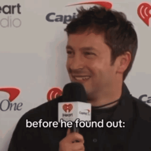 A Man Is Holding A Microphone And Smiling While Saying Before He Found Out GIF