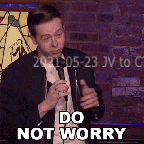 A Man Is Holding A Microphone In Front Of A Brick Wall And Says Do Not Worry GIF